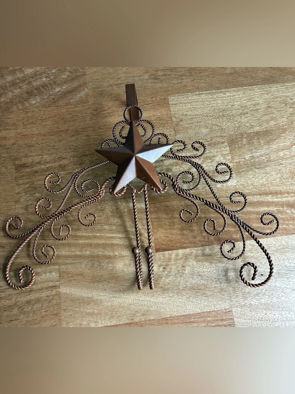 Brown metal over the door hanger features a decorative star and swirling filigre